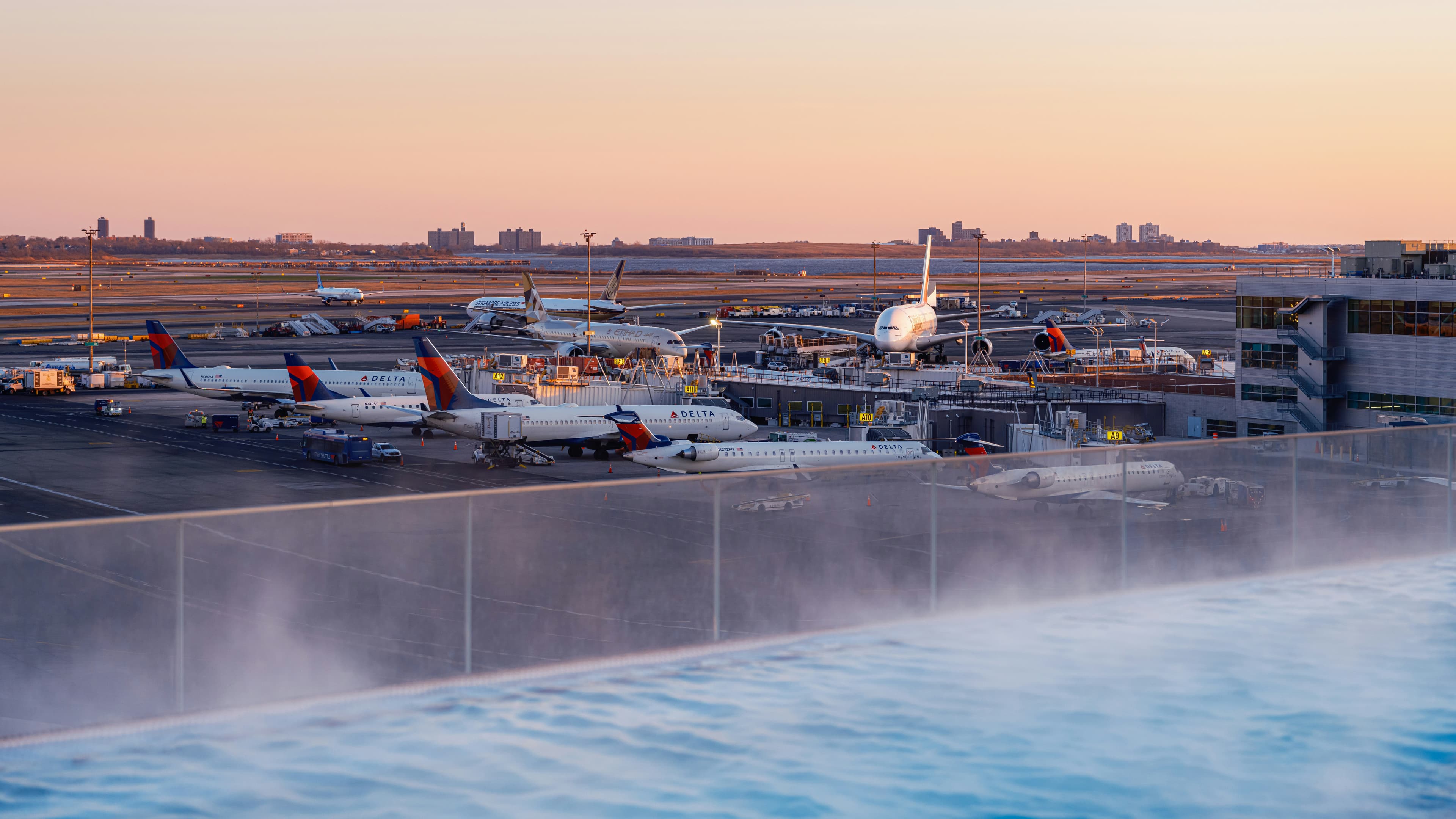 Airplanes parked at airport gates lit up at sunset